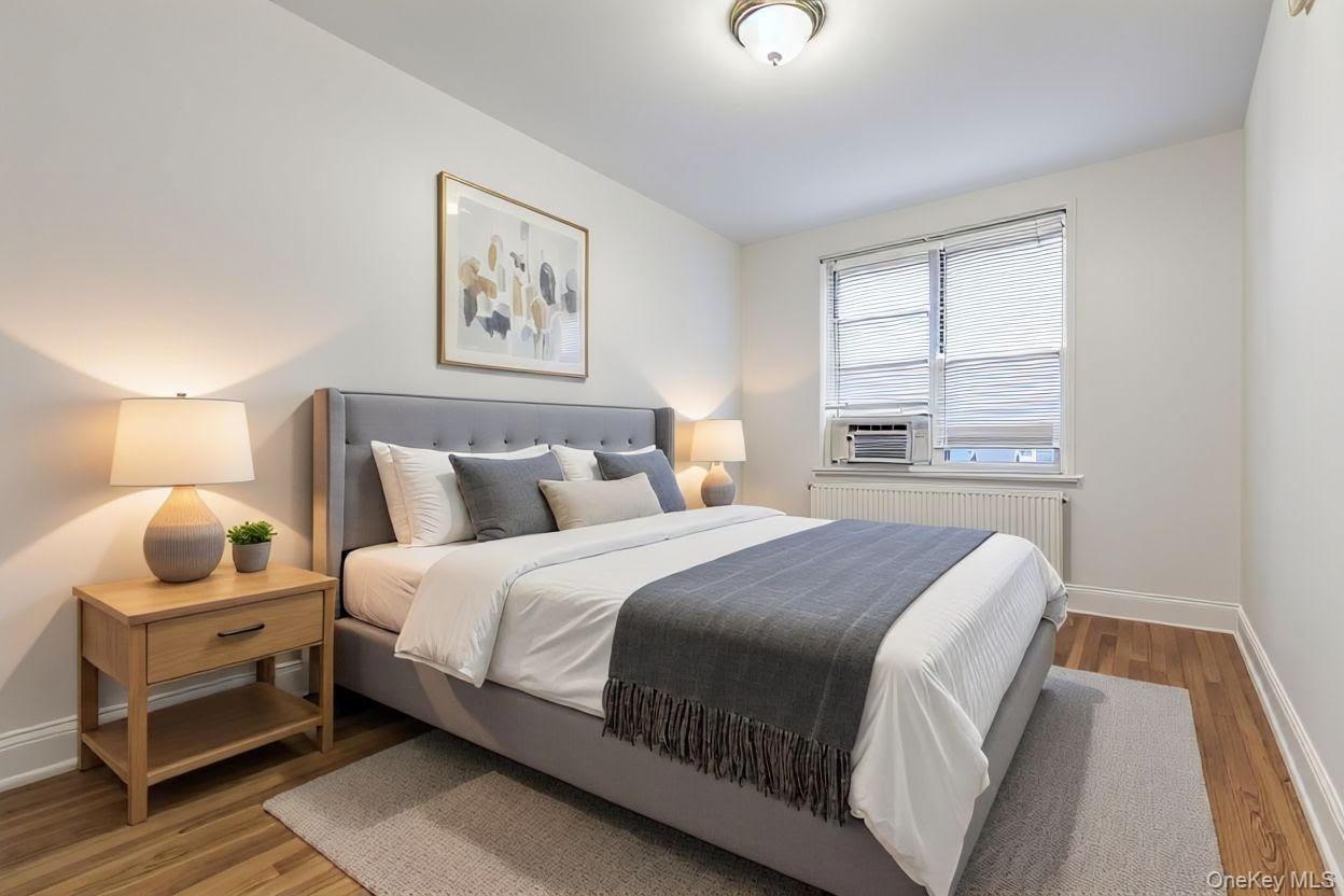 64-11 99th Street, Unit 3O4 Queens, NY 11374 - Photo 18 of 23 Bedroom featuring light wood-type flooring, radiator, and cooling unit