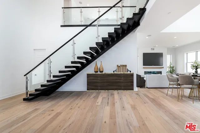 a kitchen with stainless steel appliances granite countertop a table chairs refrigerator and a stove