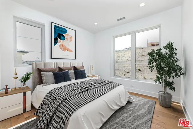a bedroom with a bed and a potted plant
