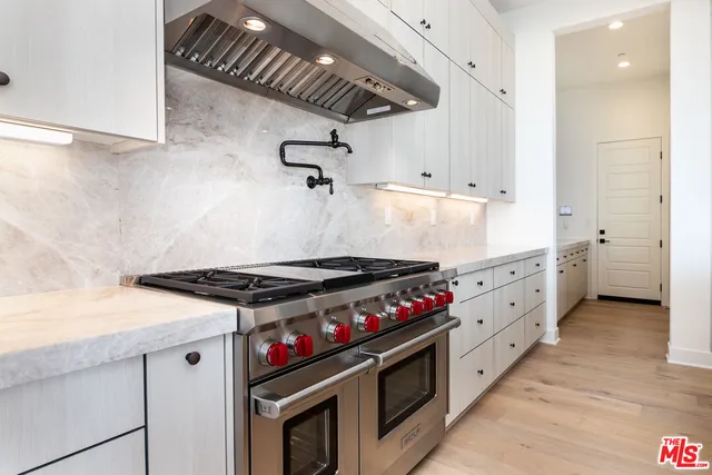 a stove top oven sitting inside of a kitchen