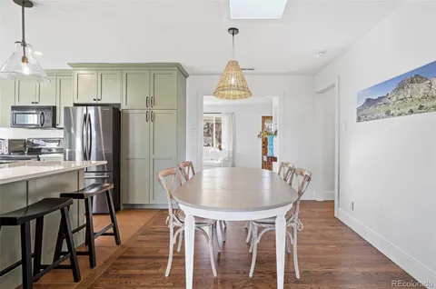 a dining room with furniture a chandelier and wooden floor
