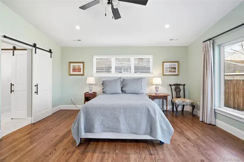 a spacious bedroom with a bed and wooden floor