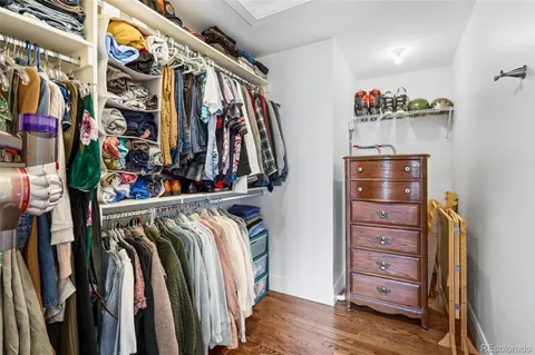 a view of walk in closet with clothes and shoes