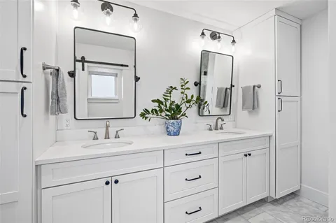 a bathroom with a double vanity sink mirror and next to a white cabinet