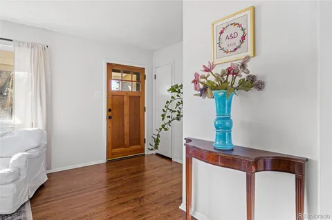 a view of a hallway with wooden floor and a potted plant