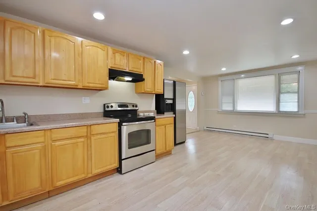 a kitchen with stainless steel appliances granite countertop a stove a sink and a refrigerator