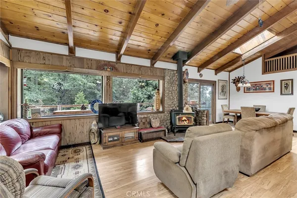 a living room with furniture a large window and wooden floor