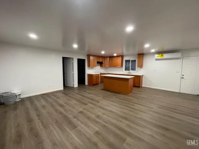 a view of kitchen and empty room with wooden floor