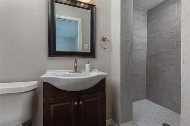 a bathroom with a sink a toilet and shower