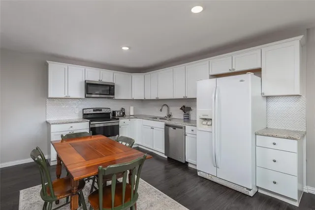 a kitchen with refrigerator cabinets and wooden floor