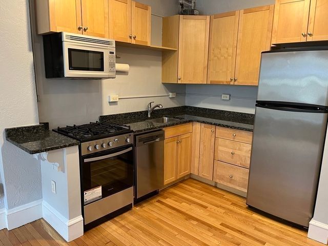 a kitchen with granite countertop cabinets and steel stainless steel appliances