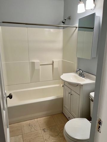 a bathroom with a sink a toilet a mirror and shower
