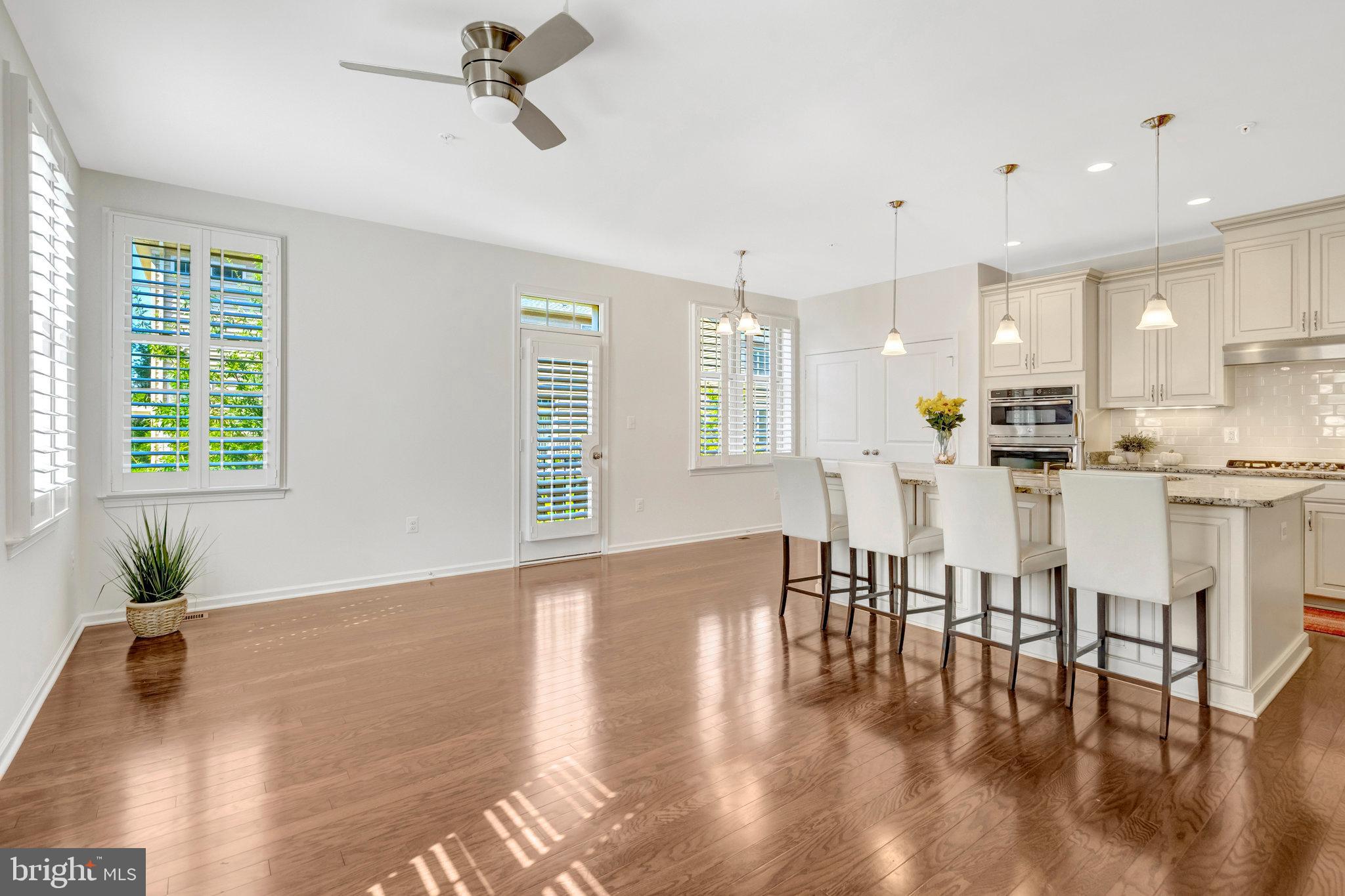 42634 Lancaster Ridge Terrace Chantilly, VA 20152 - Photo 16 of 63 a kitchen with stainless steel appliances granite countertop a stove top oven a sink a dining table and chairs with wooden floor