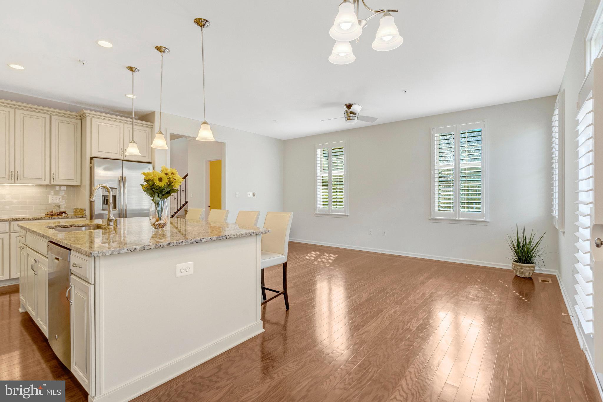42634 Lancaster Ridge Terrace Chantilly, VA 20152 - Photo 19 of 63 a kitchen with kitchen island a sink a stove a dining table and chairs