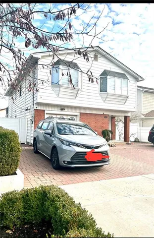 a car parked in front of a white house