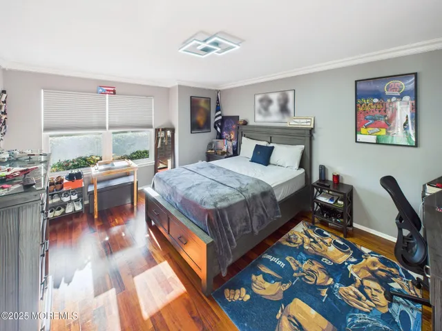 a bedroom with a bed and dresser with mirror