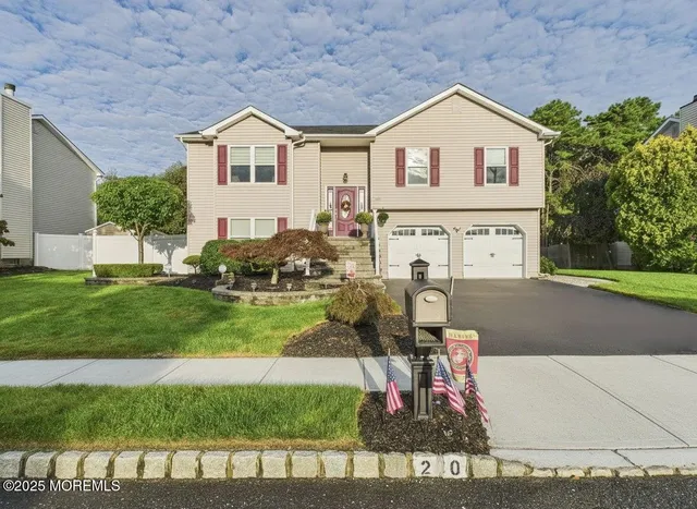 a view of a house with a big yard and a large trees