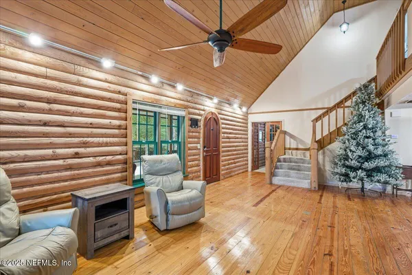a bedroom with a bed wooden floor and flat screen tv