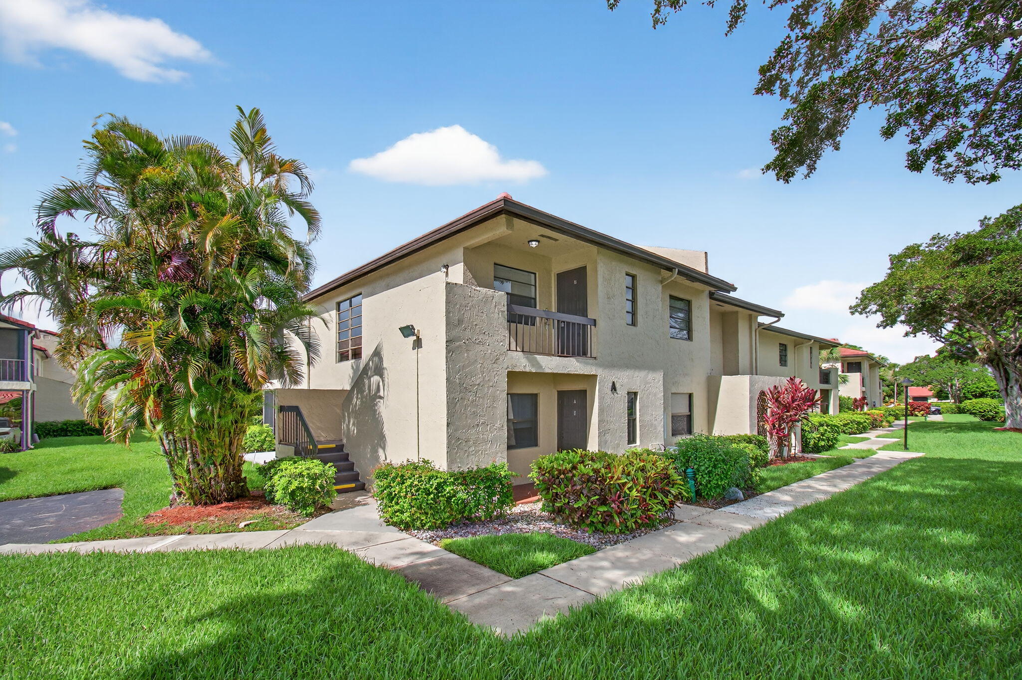 8536 Casa Del Lago, Unit 49B Boca Raton, FL 33433 - Photo 3 of 79 a front view of a house with a yard