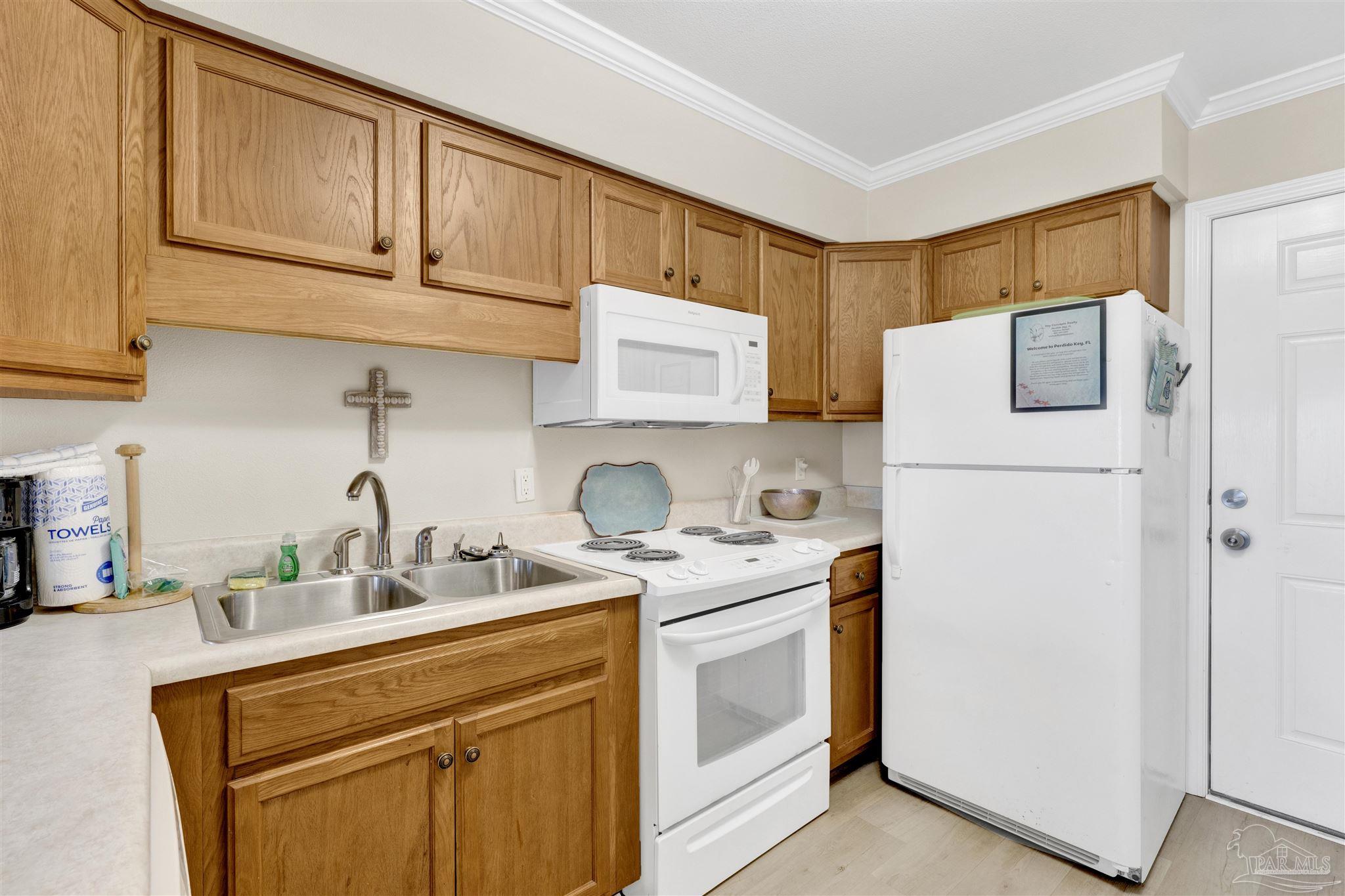 16310 Perdido Key Drive, Unit 12C Perdido Key, FL 32507 - Photo 12 of 32 a kitchen with stainless steel appliances granite countertop a refrigerator sink stove and microwave