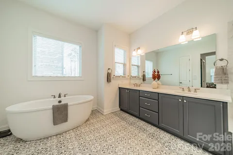 a spacious bathroom with a double vanity sink a mirror and a shower