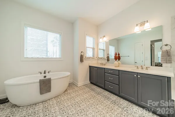 a spacious bathroom with a double vanity sink a mirror and a shower