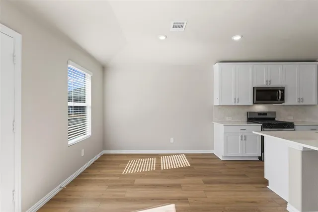 a view of kitchen with granite countertop cabinets and wooden floor