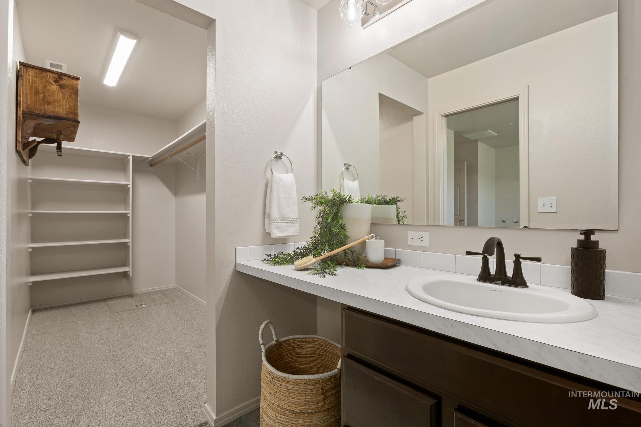 5506 Barkley Way Caldwell, ID 83607 - Photo 24 of 34 Bathroom vanity with an oval undermount sink, dark bronze-finish faucet, and a large wall-mounted mirror