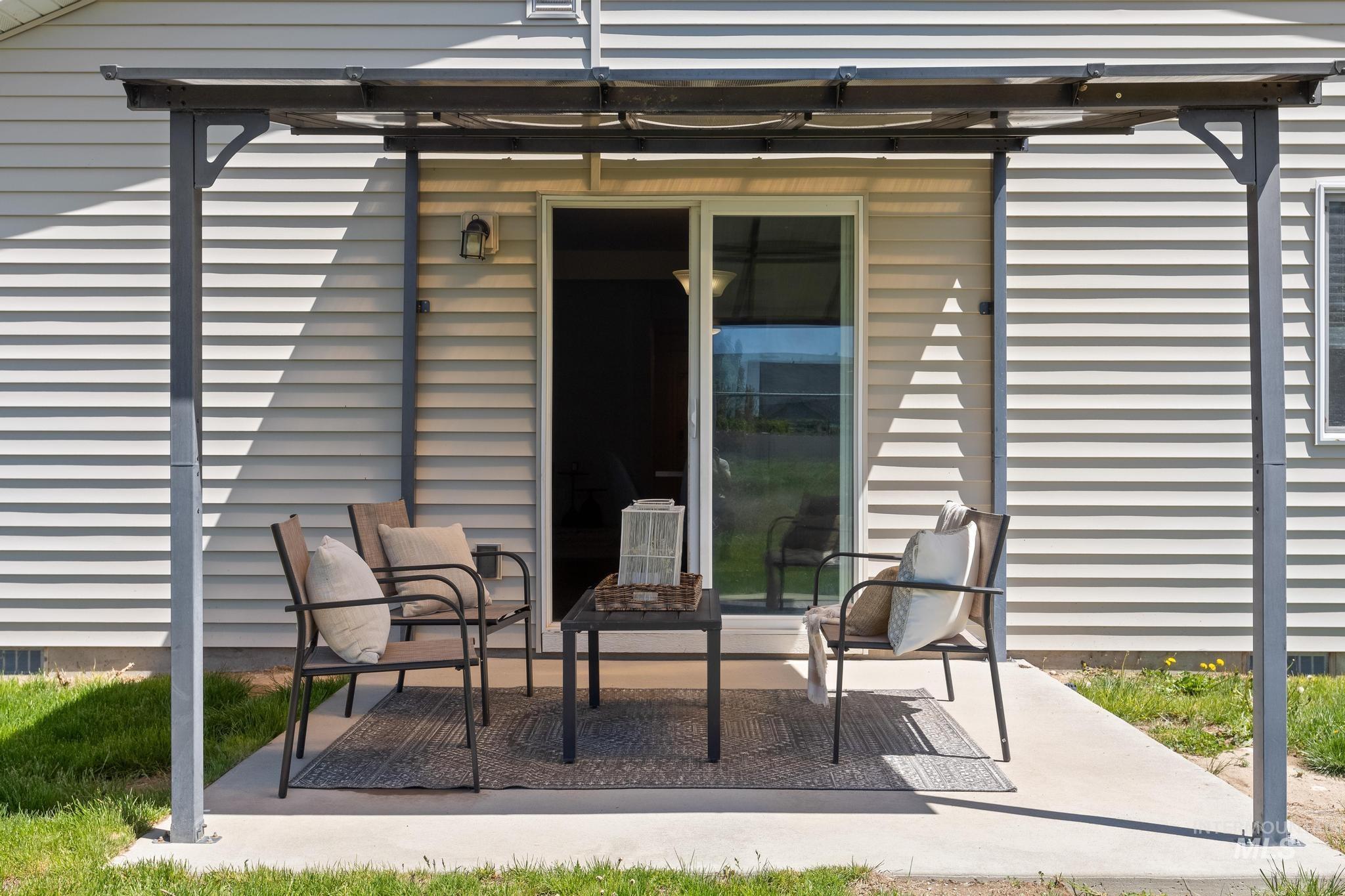 5506 Barkley Way Caldwell, ID 83607 - Photo 31 of 34 Covered patio featuring a sliding glass door, exterior wall lantern, and light-colored siding