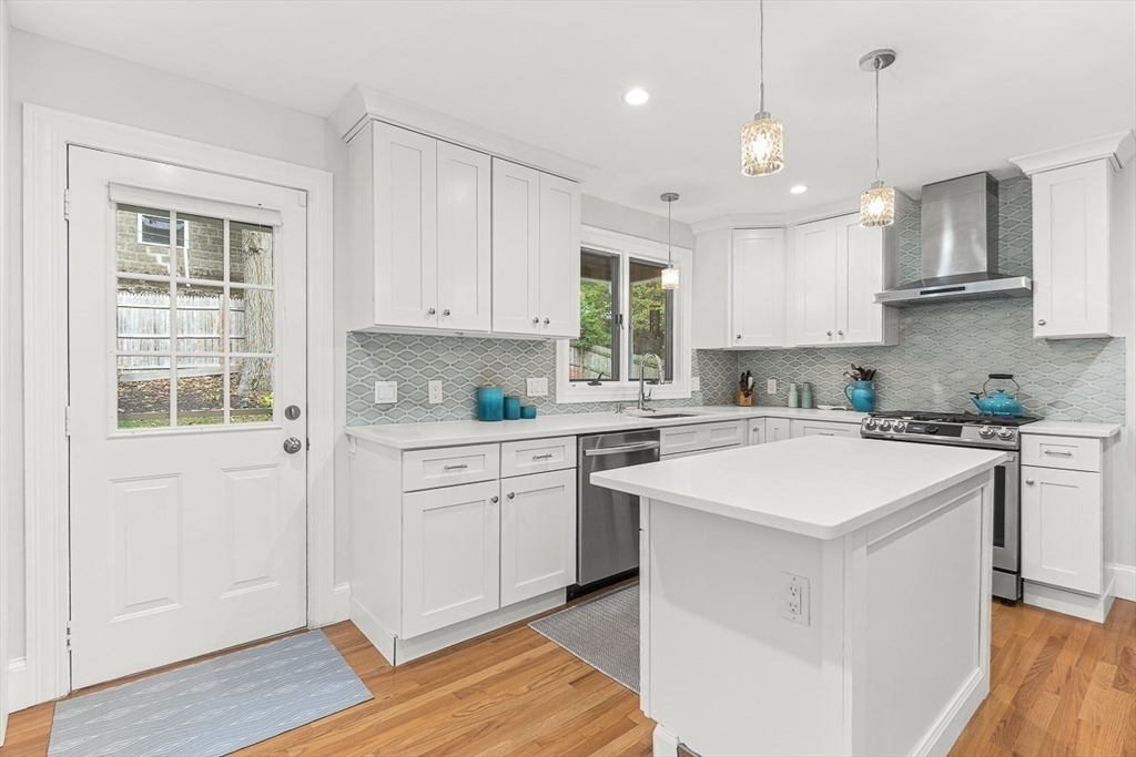 55 Redlands Road Boston, MA 02132 - Photo 15 of 42 a kitchen with stainless steel appliances granite countertop a sink a stove a refrigerator and white cabinets with wooden floor