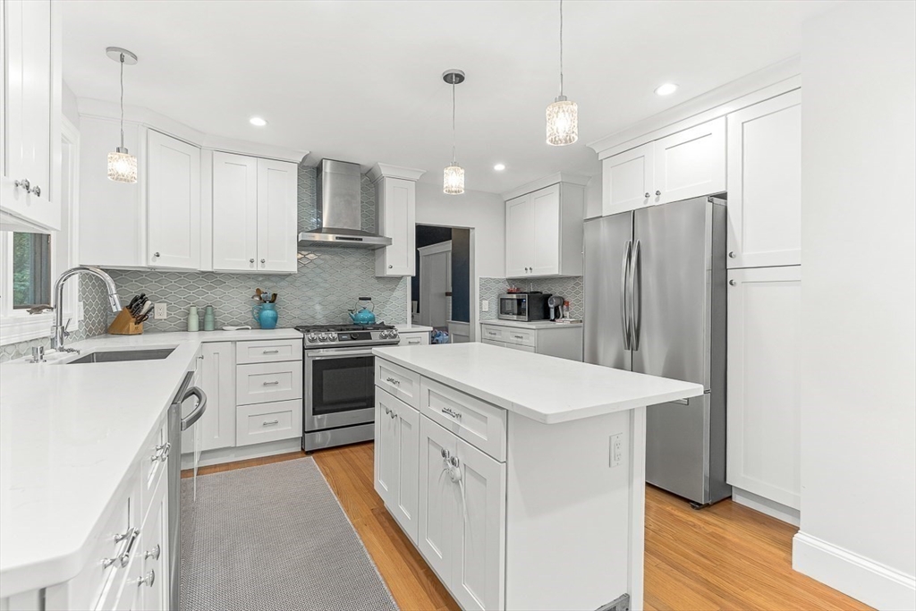 55 Redlands Road Boston, MA 02132 - Photo 16 of 42 a kitchen with white cabinets and stainless steel appliances