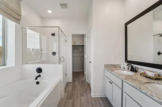 a bathroom with a tub sink and mirror