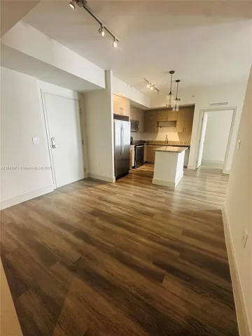 a view of a kitchen with kitchen island a sink stainless steel appliances and cabinets