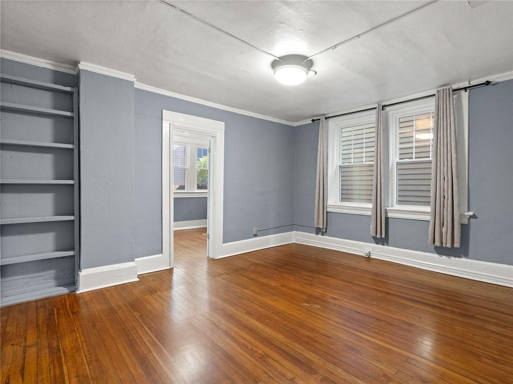 164 4th Street Northeast, Unit 9 Atlanta, GA 30308 - Photo 8 of 18 a view of an empty room with wooden floor and a window