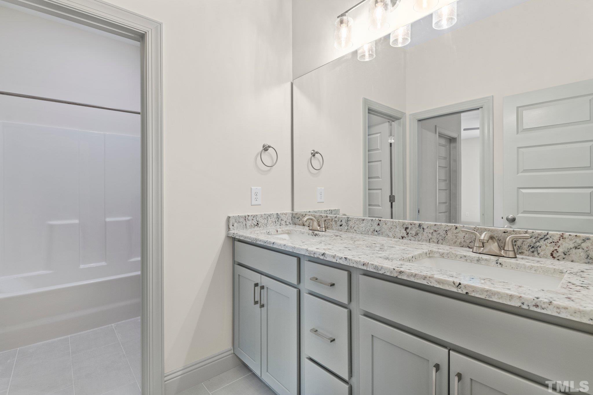 456 Reese Drive Willow Spring, NC 27592 - Photo 41 of 50 a bathroom with a granite countertop sink and a mirror