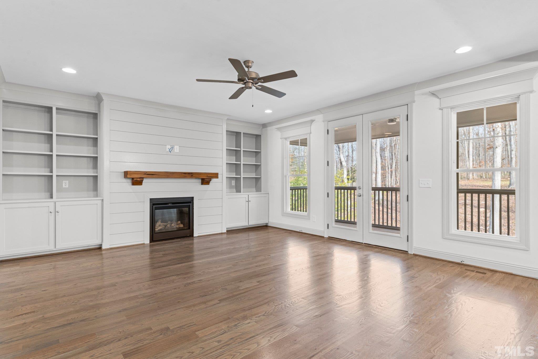 456 Reese Drive Willow Spring, NC 27592 - Photo 8 of 50 an empty room with wooden floor fireplace and windows