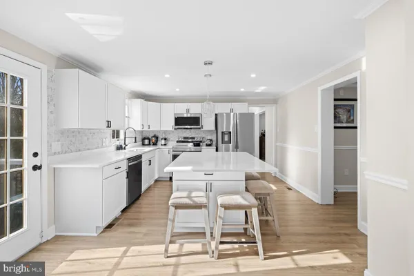 a large white kitchen with stainless steel appliances