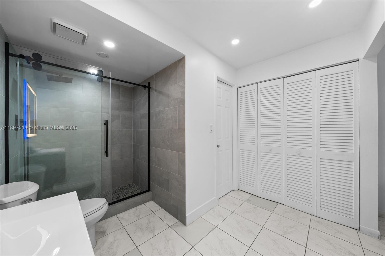 401 Golden Isles Drive, Unit 304 Hallandale Beach, FL 33009 - Photo 11 of 43 a bathroom with a shower and a toilet