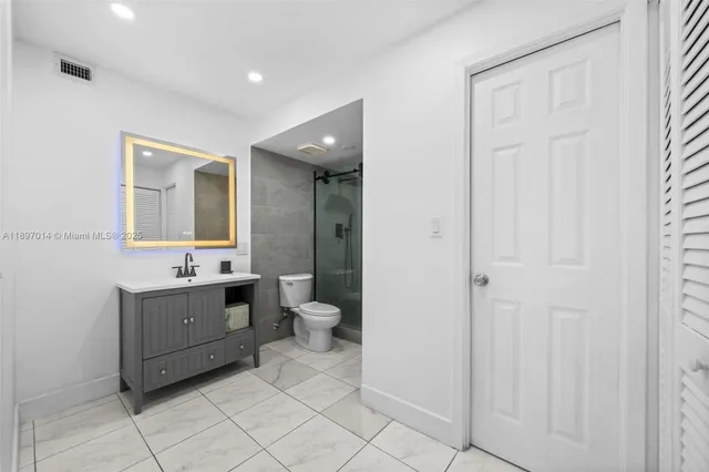 a bathroom with a sink a toilet and mirror