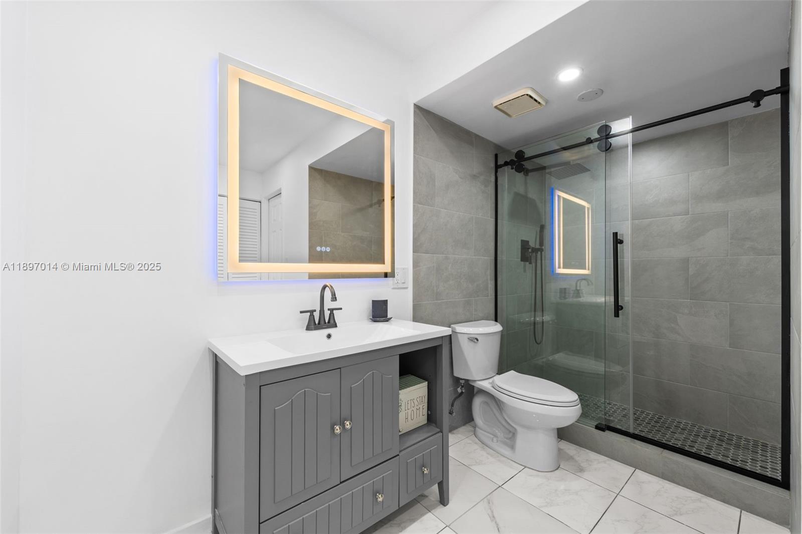 401 Golden Isles Drive, Unit 304 Hallandale Beach, FL 33009 - Photo 13 of 43 a bathroom with a toilet sink and mirror