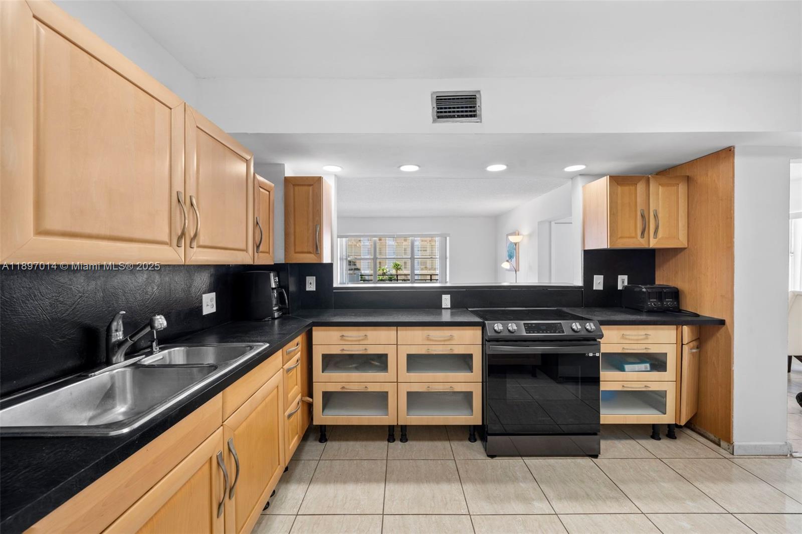 401 Golden Isles Drive, Unit 304 Hallandale Beach, FL 33009 - Photo 14 of 43 a kitchen with stainless steel appliances granite countertop a sink and cabinets