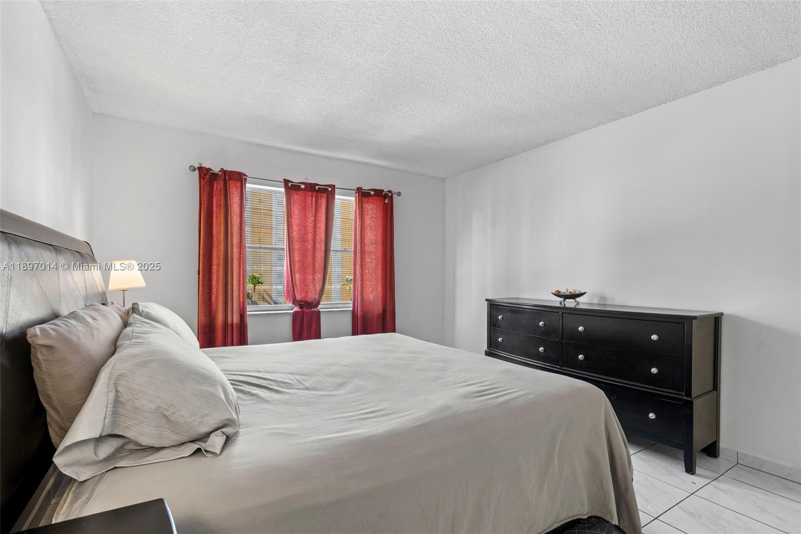 401 Golden Isles Drive, Unit 304 Hallandale Beach, FL 33009 - Photo 16 of 43 a bedroom with a bed and a large window