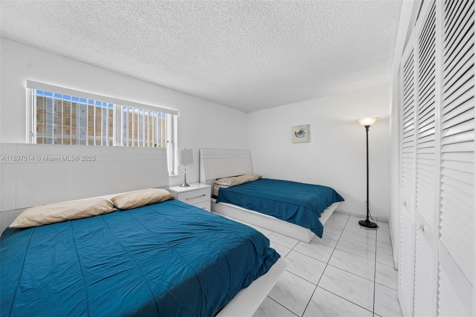 401 Golden Isles Drive, Unit 304 Hallandale Beach, FL 33009 - Photo 20 of 43 a bedroom with two beds and a window