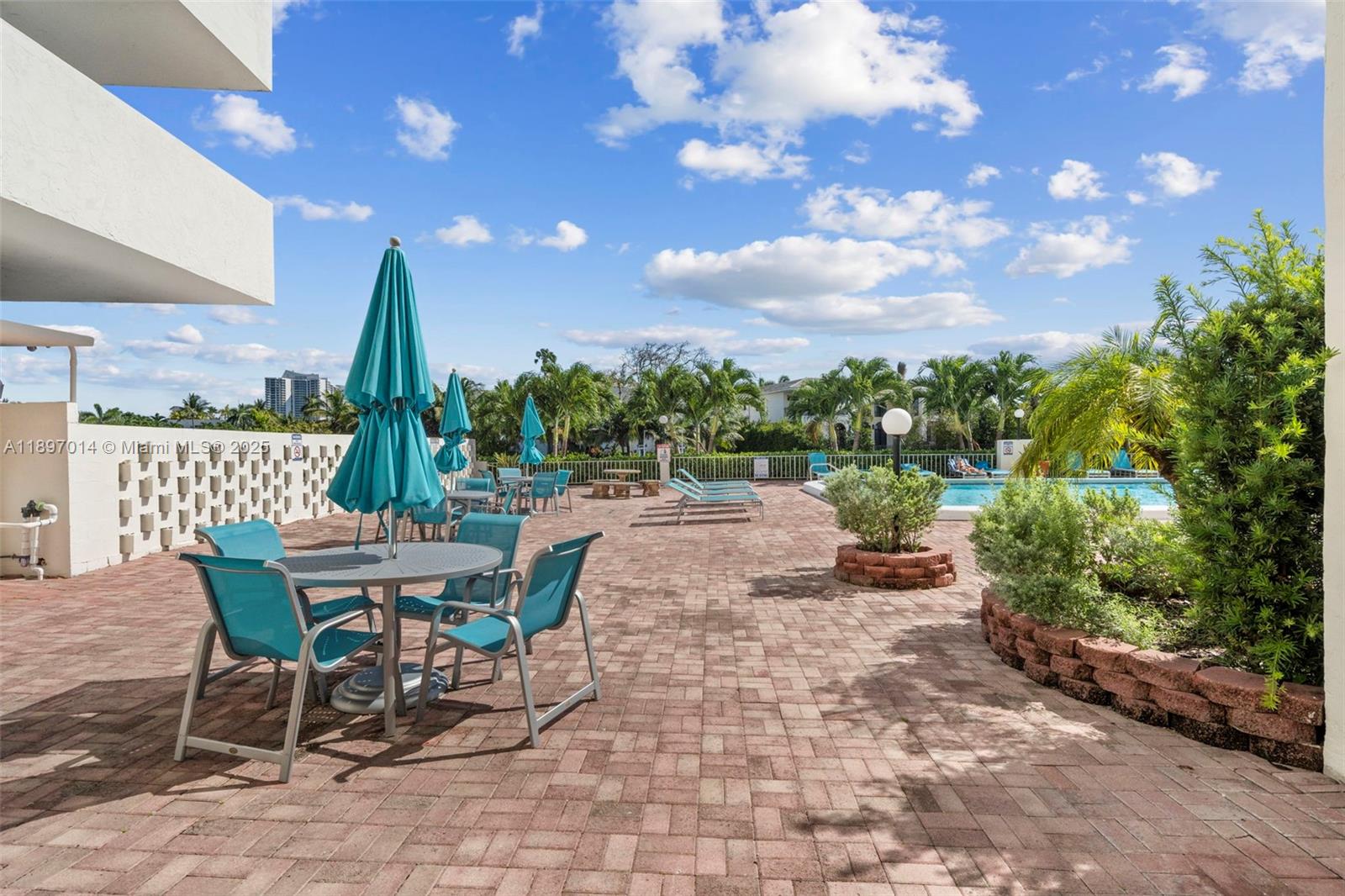 401 Golden Isles Drive, Unit 304 Hallandale Beach, FL 33009 - Photo 28 of 43 a view of a patio with a table and chairs