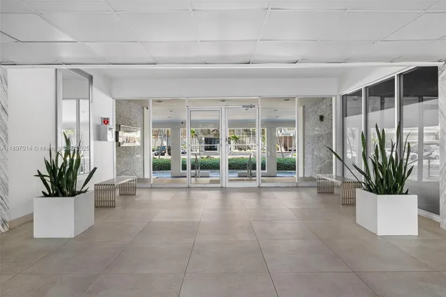 a view of a hallway with wooden floor and a potted plant