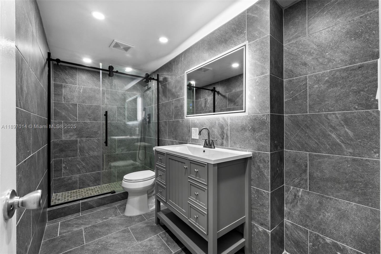 401 Golden Isles Drive, Unit 304 Hallandale Beach, FL 33009 - Photo 5 of 43 a bathroom with a sink toilet and shower