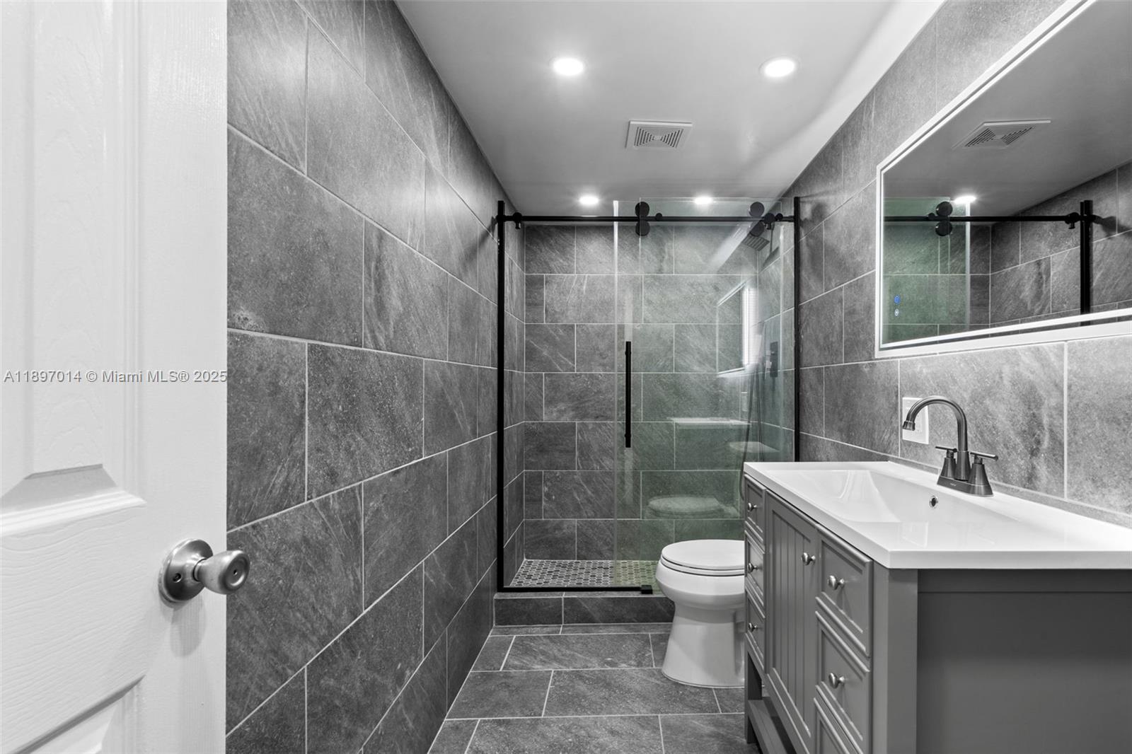 401 Golden Isles Drive, Unit 304 Hallandale Beach, FL 33009 - Photo 6 of 43 a bathroom with a sink toilet and shower