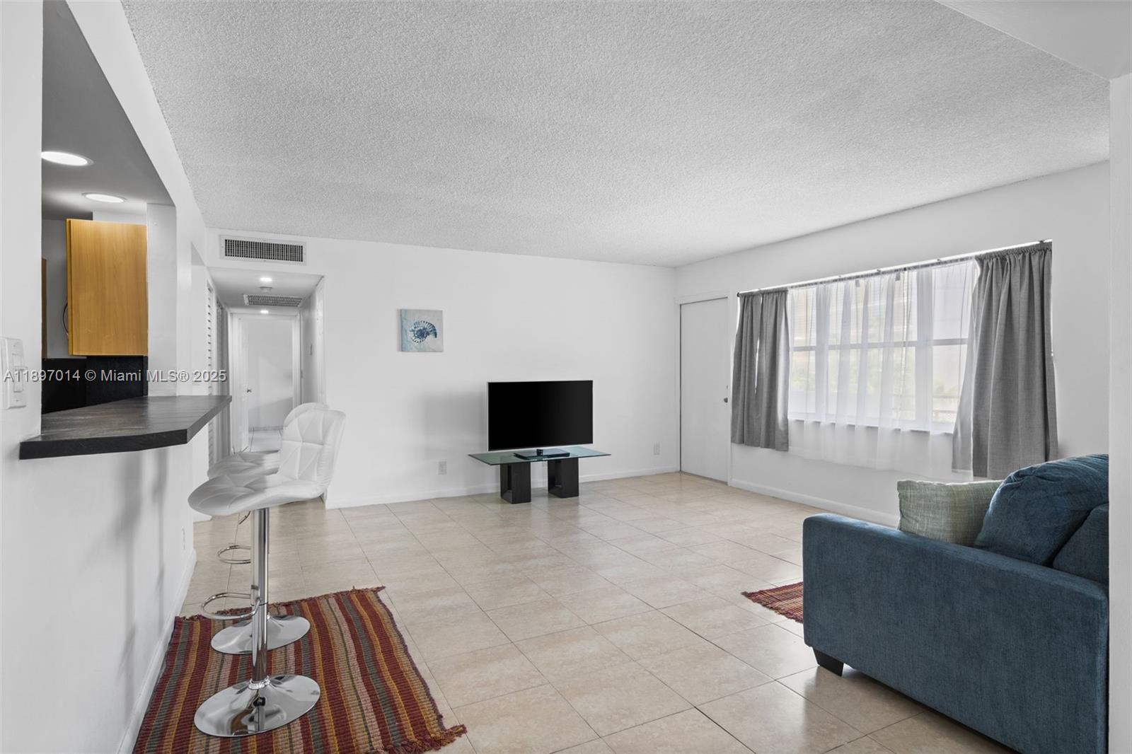 401 Golden Isles Drive, Unit 304 Hallandale Beach, FL 33009 - Photo 8 of 43 a living room with furniture and a flat screen tv