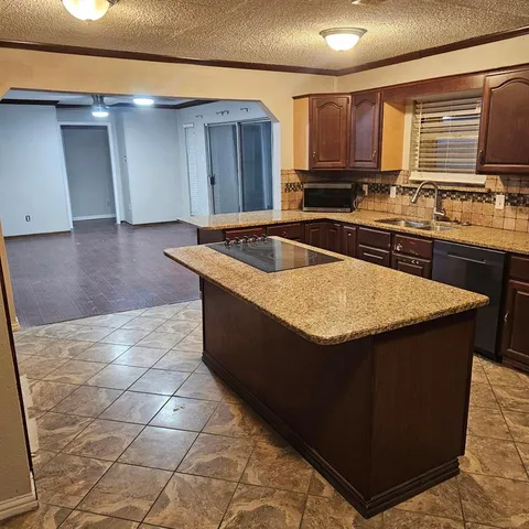a kitchen with granite countertop a sink and a stove top oven