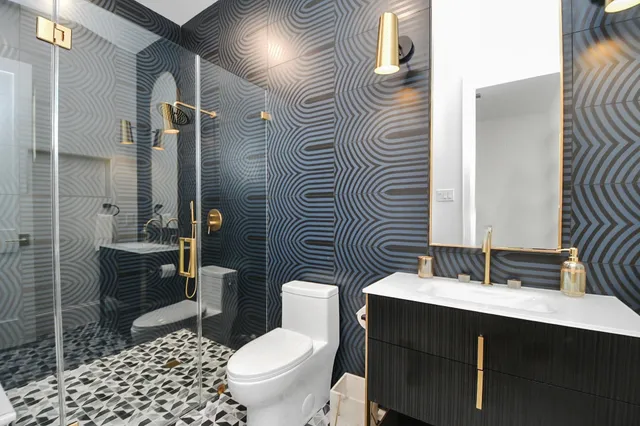 a bathroom with a sink a toilet and shower